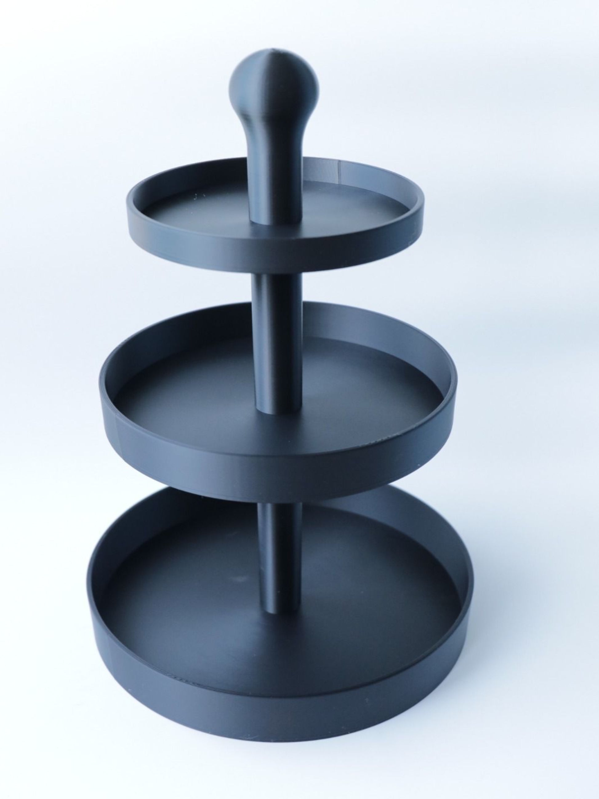 Zwarte 3D-geprinte ronde etagère van 34 cm hoog, ideaal voor hapjes, fruit en snacks op tafel.